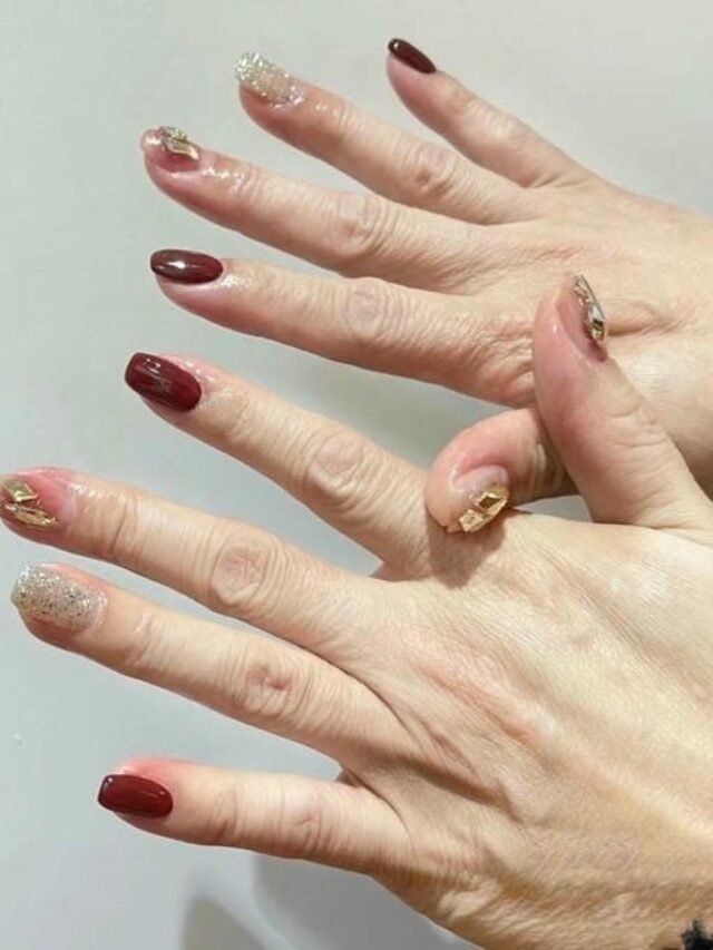 Nail màu đỏ mận kết hợp nhũ và đá khối sang trọng cho người trung tuổi